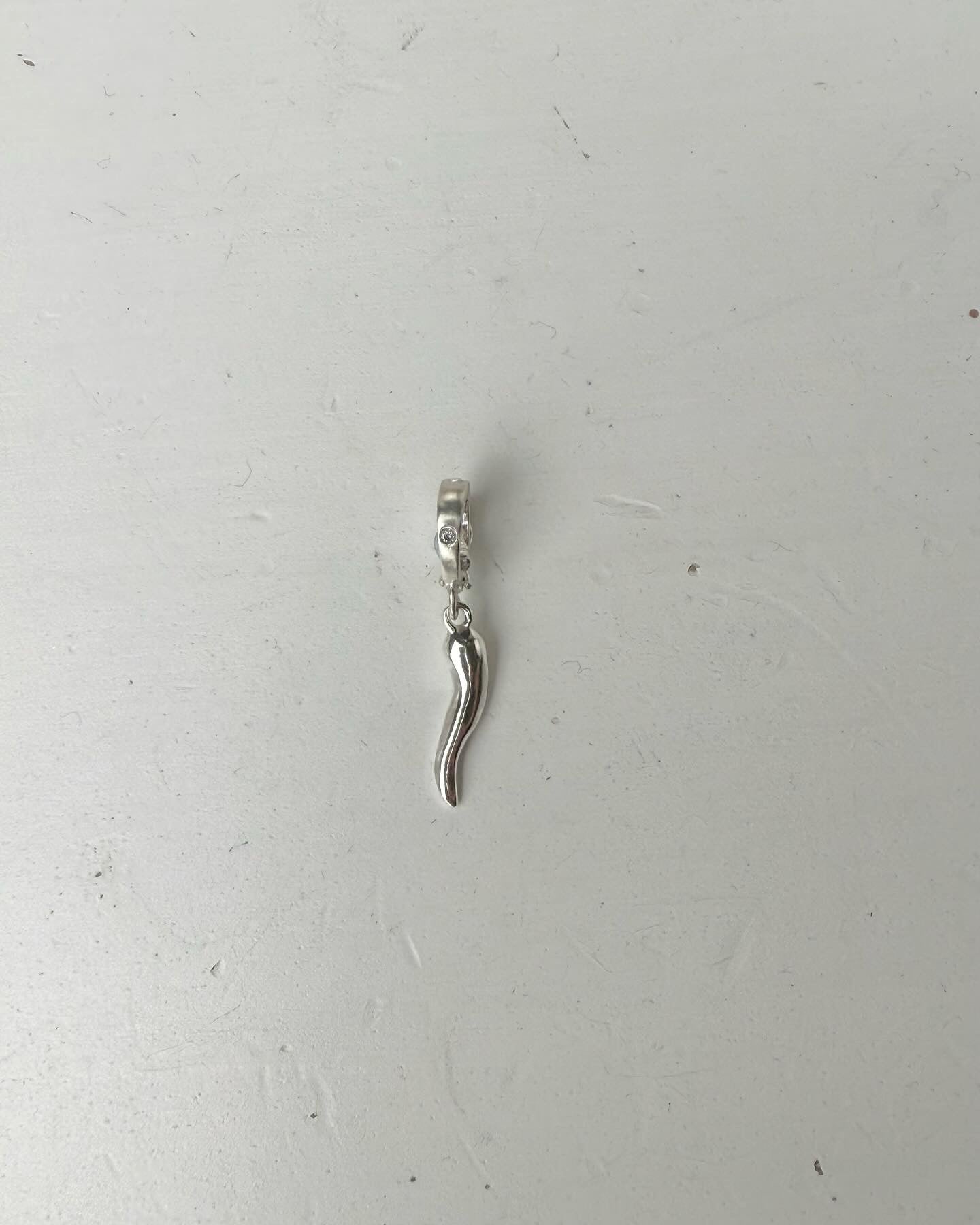 Horn pendant in sterling silver + salt & pepper diamond —> flush setting in the bail.